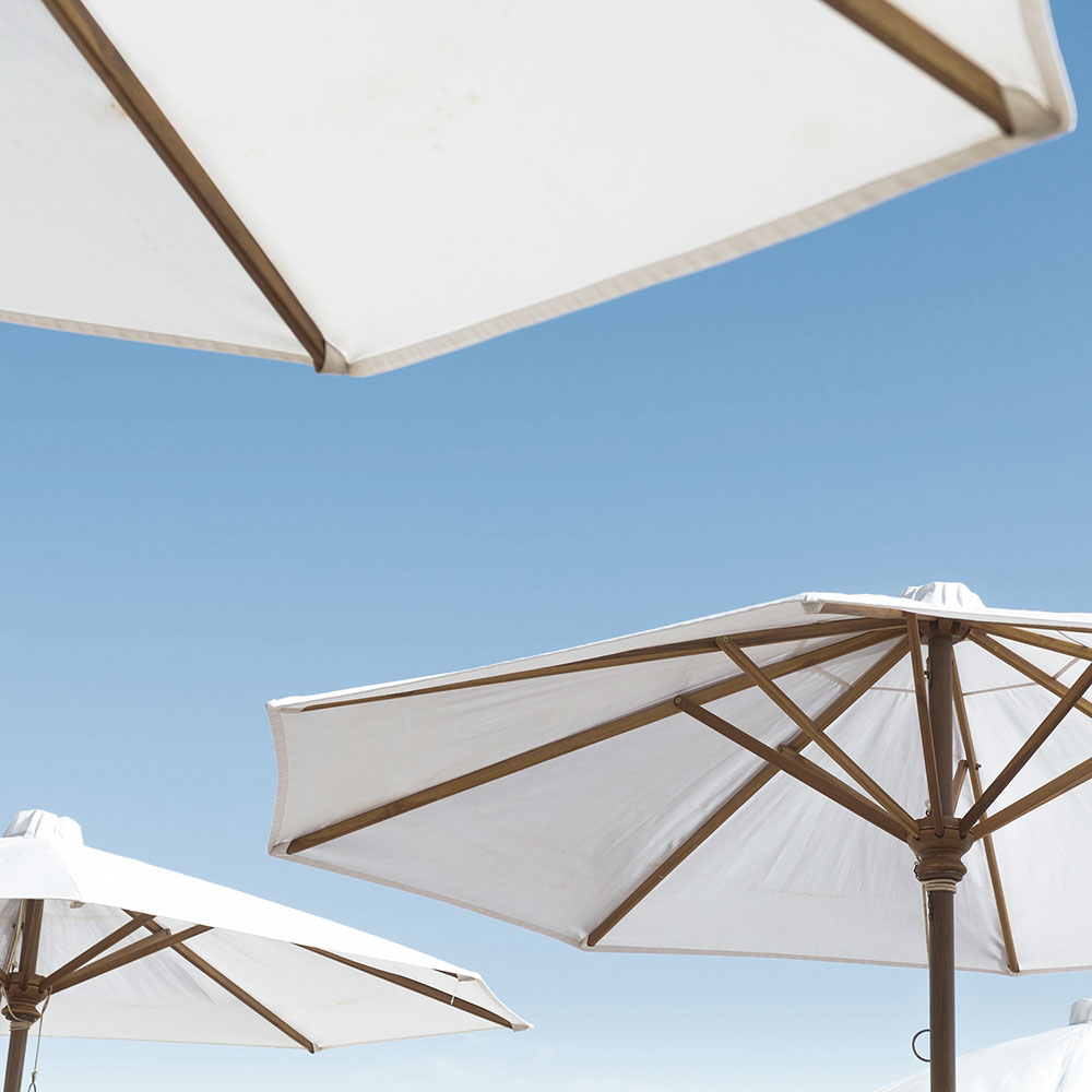 estate-enhancement-conservation A collection of white umbrellas arranged on a sandy beach in Vancouver, British Columbia
